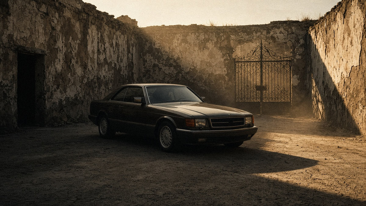 Vintage coupe parked in a crumbling concrete courtyard at golden hour — generated mood image