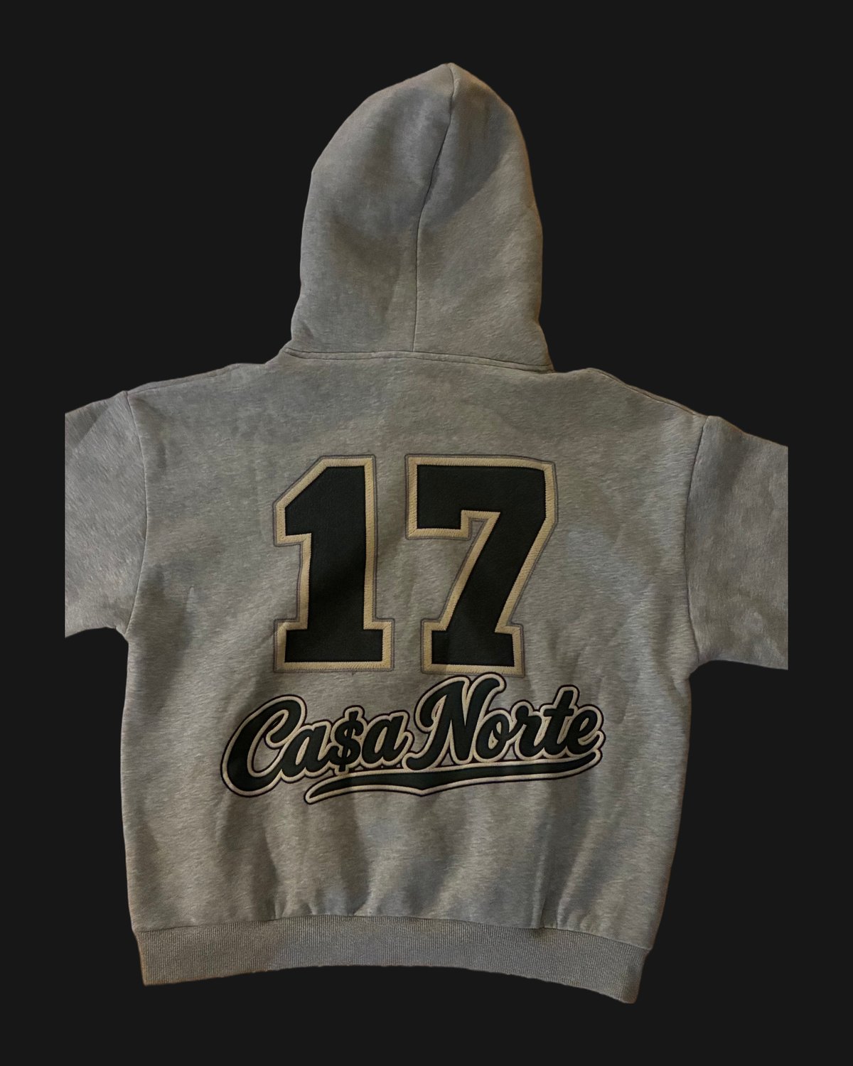 Back of the heather gray Ca$a Norte hoodie with black 17 and script logo outlined in cream